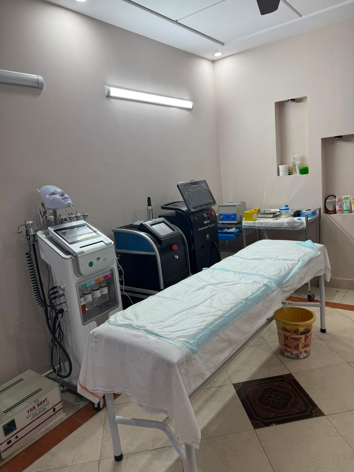 Skin Lounge by Rasha treatment room with aesthetic machines and a prepared treatment bed.
